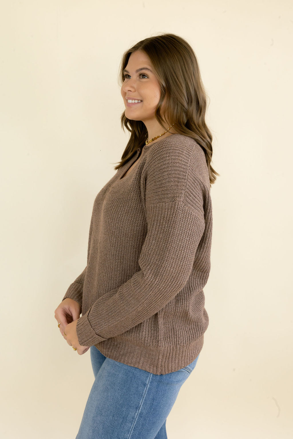 Three-quarter view of taupe brown V-neck knit sweater showing textured knit fabric, long sleeves, and relaxed everyday fit
