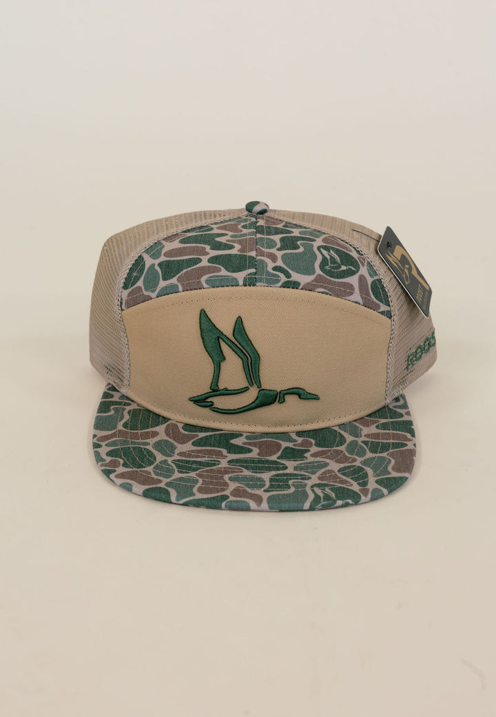 Close-up of tan and green camo waterfowl trucker cap featuring embroidered duck logo, camouflage bill and crown, and mesh back