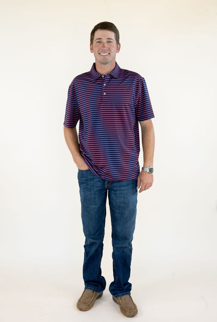 Front view of blue and red striped men’s performance polo featuring short sleeves, button placket, classic collar, and relaxed fit