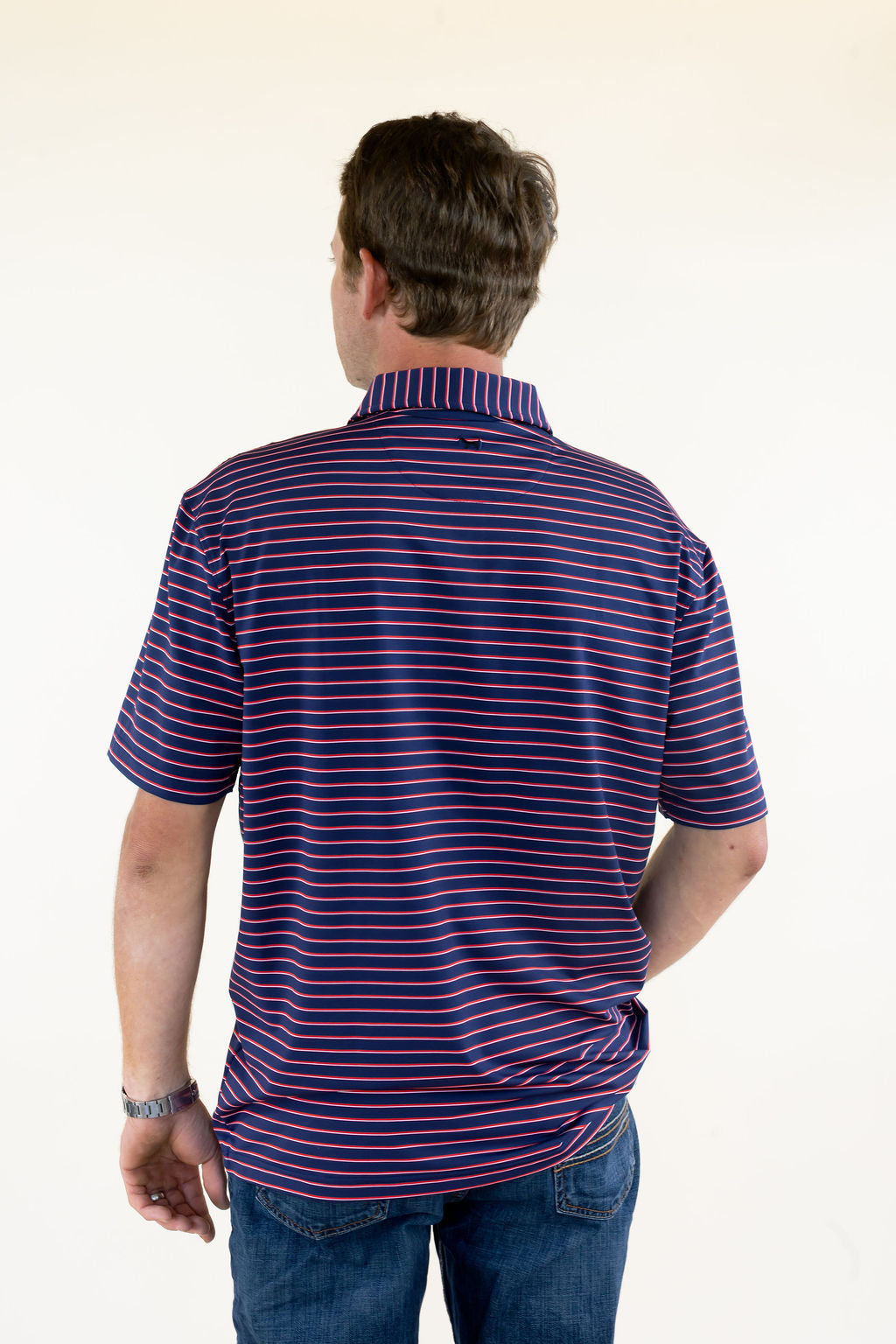 Close-up back view of blue and red striped performance polo highlighting the horizontal stripe pattern, structured collar, and small back neck logo