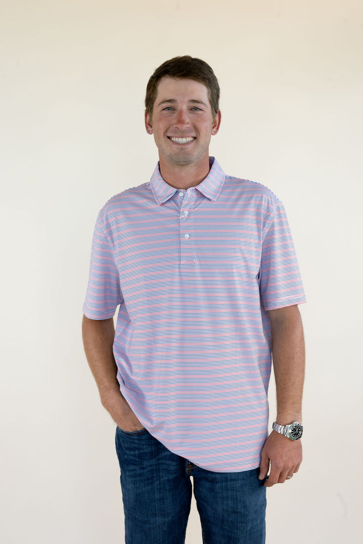 Male model wearing a cream striped short sleeve performance polo shirt with a collared neckline, front view. with blue jeans, full-body front view.