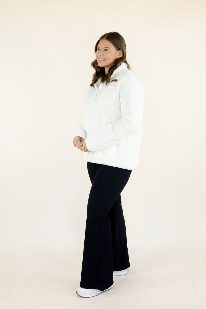 Simply Southern Simply Soft Pullover in ivory featuring plush textured fabric, snap-button collar, and front pockets, styled with black flare pants.