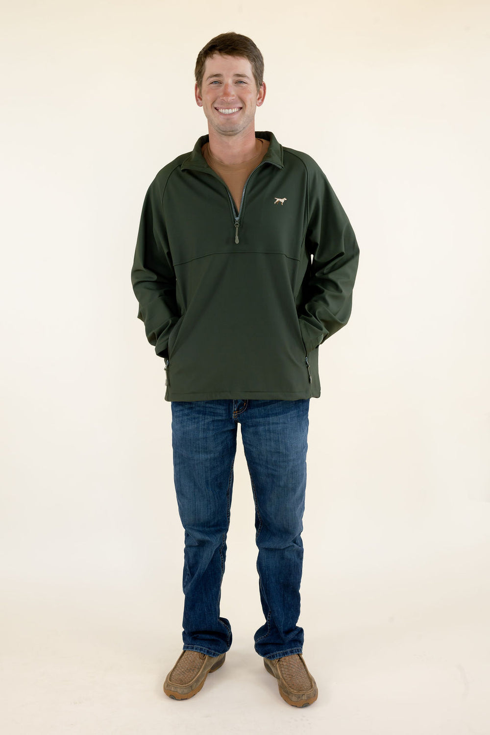 Male model wearing the green Dogwood soft shell quarter zip pullover with blue jeans, full-body front view.