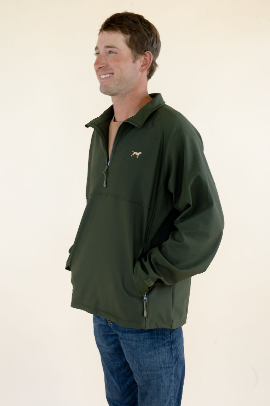 Side view of male model wearing the green Dogwood soft shell quarter zip pullover showing the fit and silhouette.