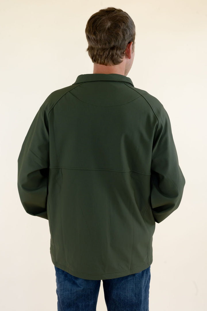Back view of male model wearing the green Dogwood Pullover showing the solid green soft shell construction and rear fit.