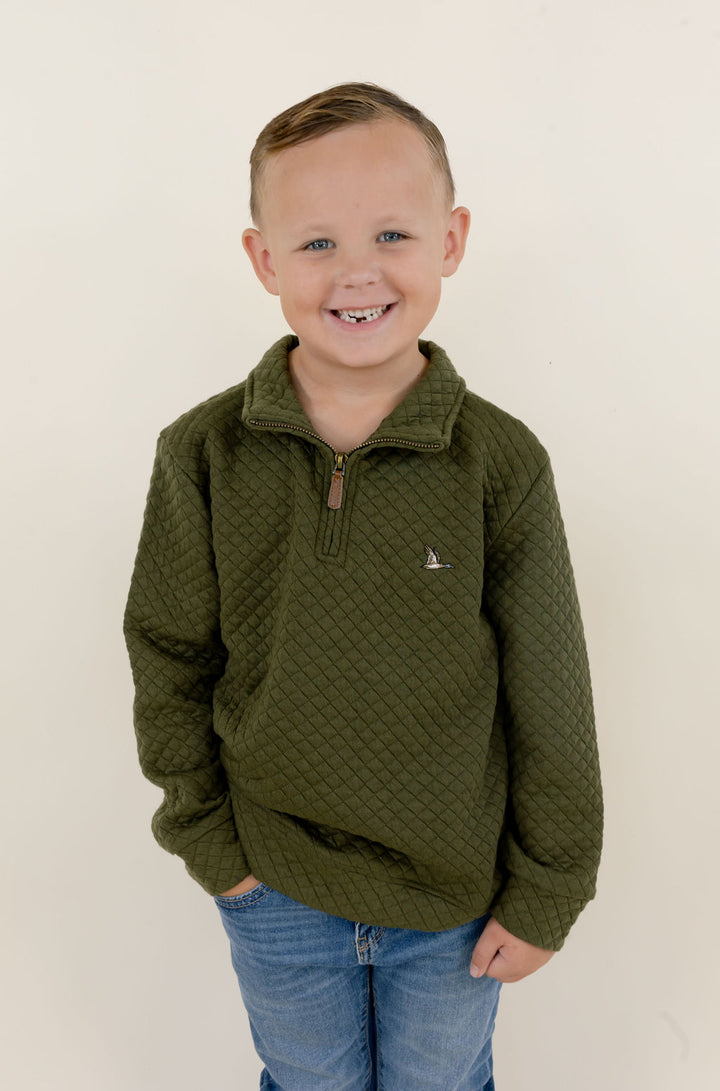 Front view of youth model wearing the green Roost Drake soft-shell quarter zip pullover with chest logo and zippered pockets.