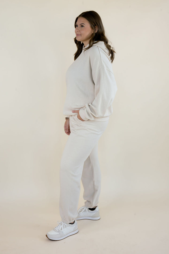 Full-length side view of First Quarter Hoodie in Frosted Pearl styled with matching fleece joggers and white sneakers.