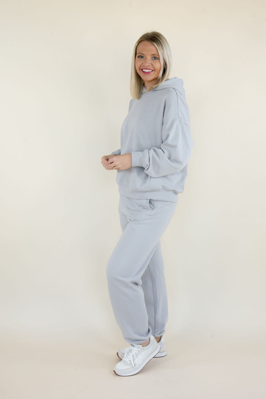 Side view of First Quarter Hoodie in Silverlake styled with matching fleece joggers and white sneakers, highlighting the relaxed silhouette.