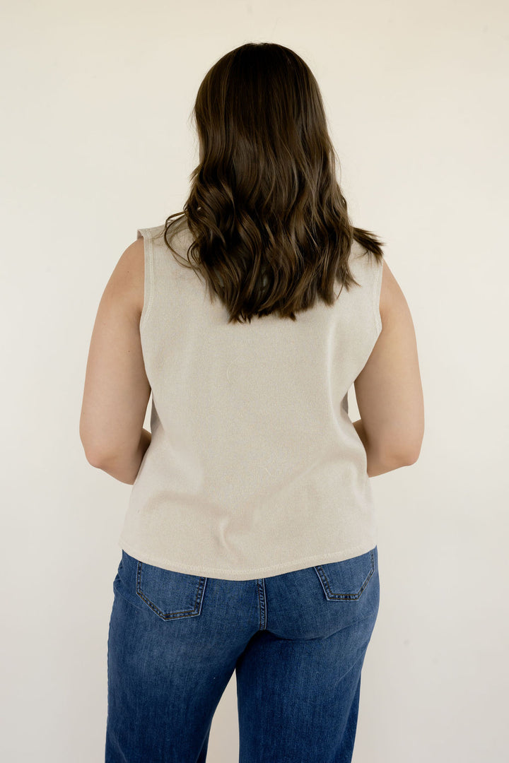 Back view of cream sleeveless mock neck sweater top showing the sleeveless design, relaxed silhouette, and hip-length hem