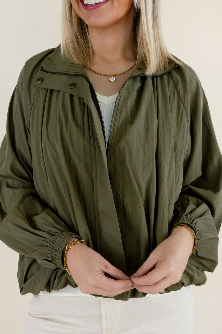 Close-up of olive green collared blouse highlighting the gathered fabric, open neckline, balloon sleeves, and relaxed silhouette
