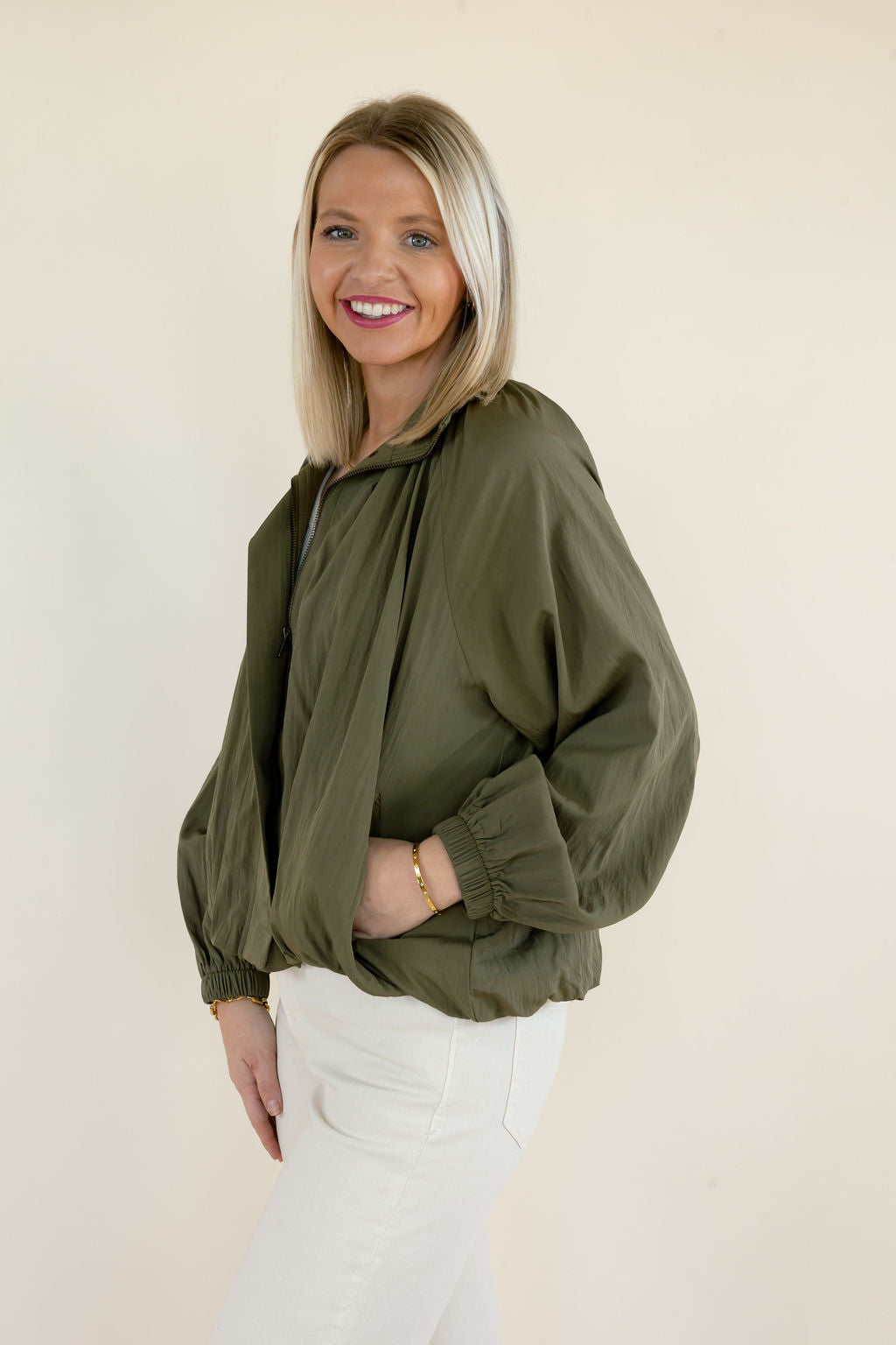 Three-quarter view of olive green long sleeve blouse highlighting the collared neckline, gathered detailing, and voluminous sleeves