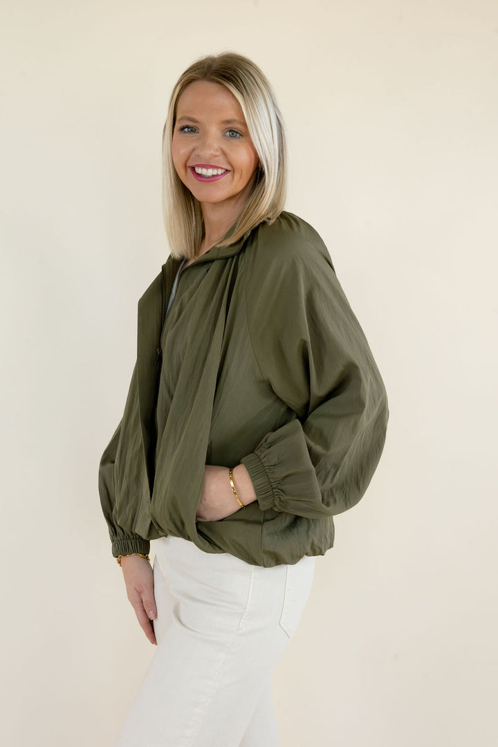 Three-quarter view of olive green long sleeve blouse highlighting the collared neckline, gathered detailing, and voluminous sleeves