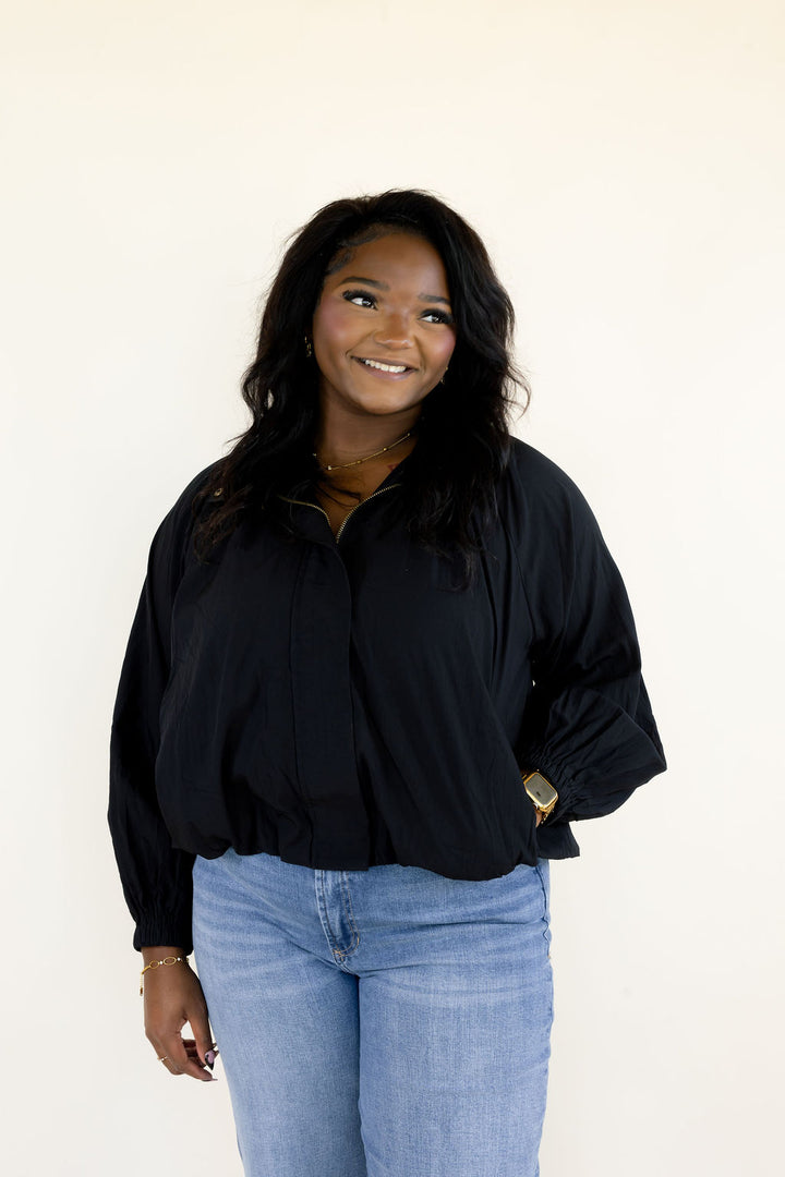Front view of black balloon sleeve blouse featuring collared neckline, gathered bodice, long sleeves, and relaxed fit