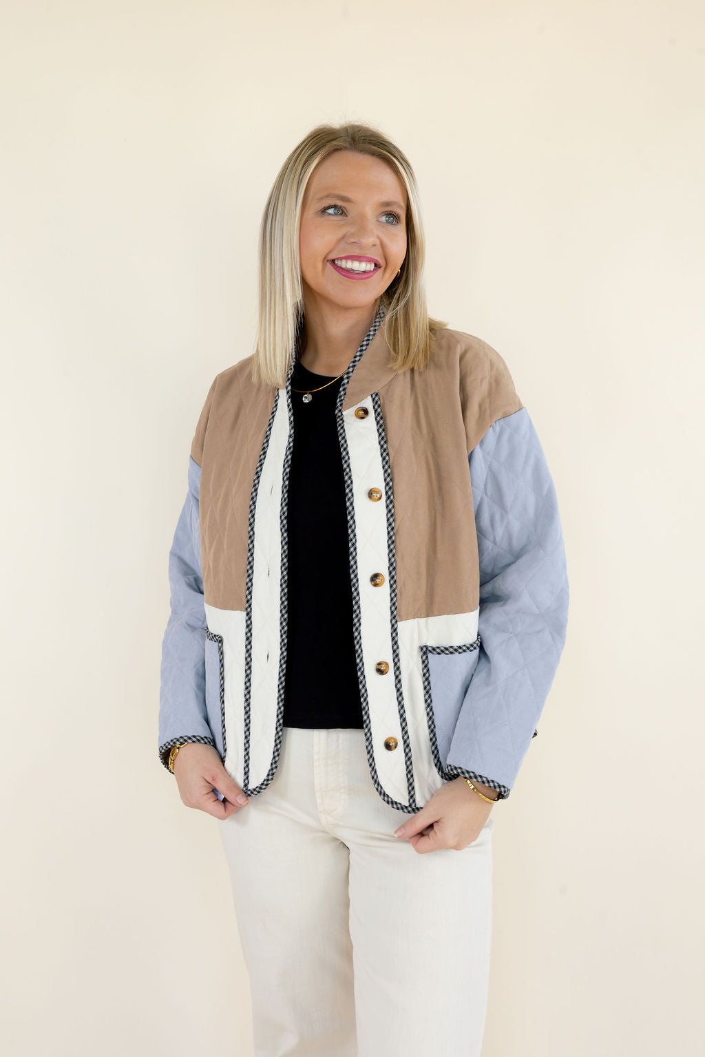 Woman wearing camel, ivory, and light blue quilted jacket with round neckline, button-front closure, long sleeves, and relaxed fit