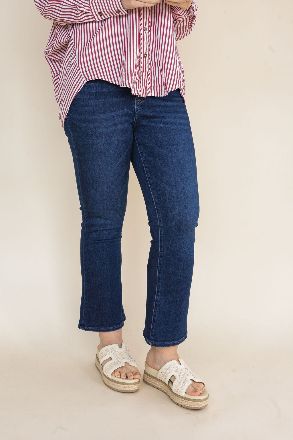 Woman wearing dark wash straight leg ankle jeans styled with a red and white striped button-down shirt and ivory platform slide sandals for a casual everyday outfit.
