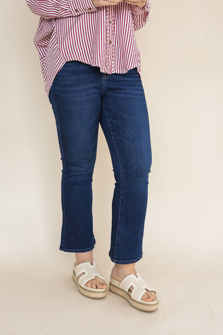 Woman wearing dark wash straight leg ankle jeans styled with a red and white striped button-down shirt and ivory platform slide sandals for a casual everyday outfit.