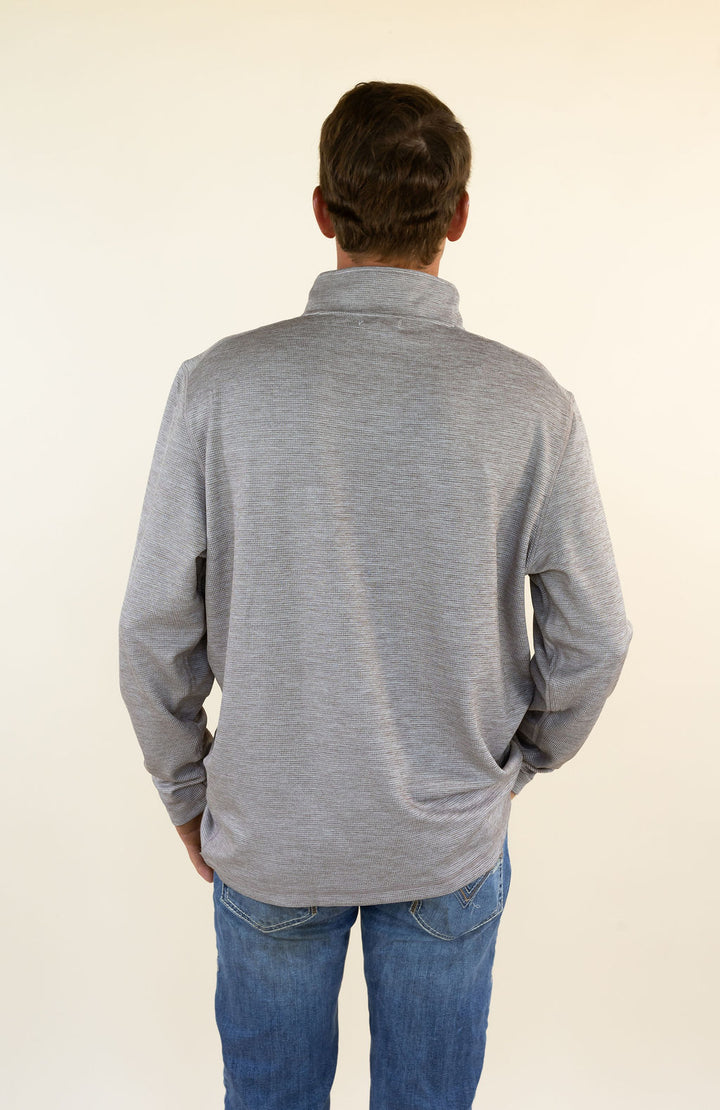 A man viewed from behind wearing a heather brown long-sleeve quarter-zip pullover and blue jeans, standing against a plain off-white background.