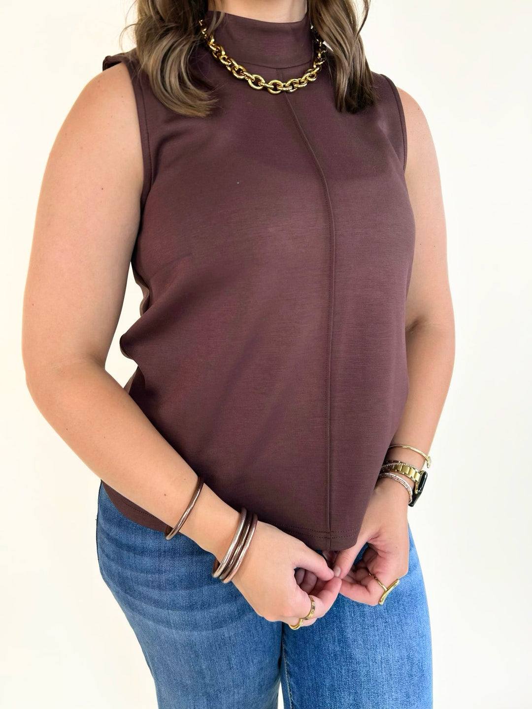 Close-up of the brown sleeveless mock neck knit top showing the neckline and soft stretch fabric.