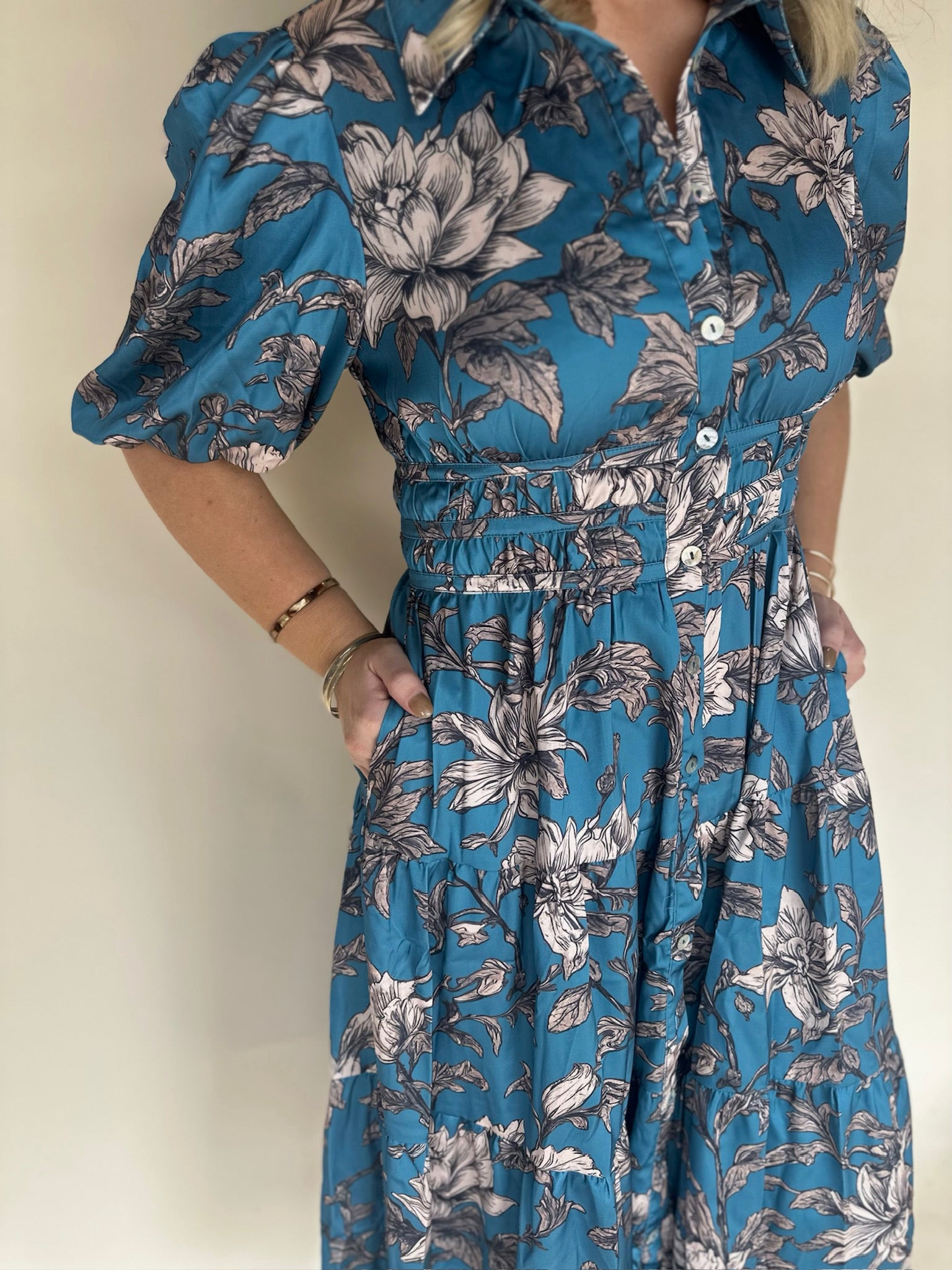 Blue floral dress worn by a person against a plain background