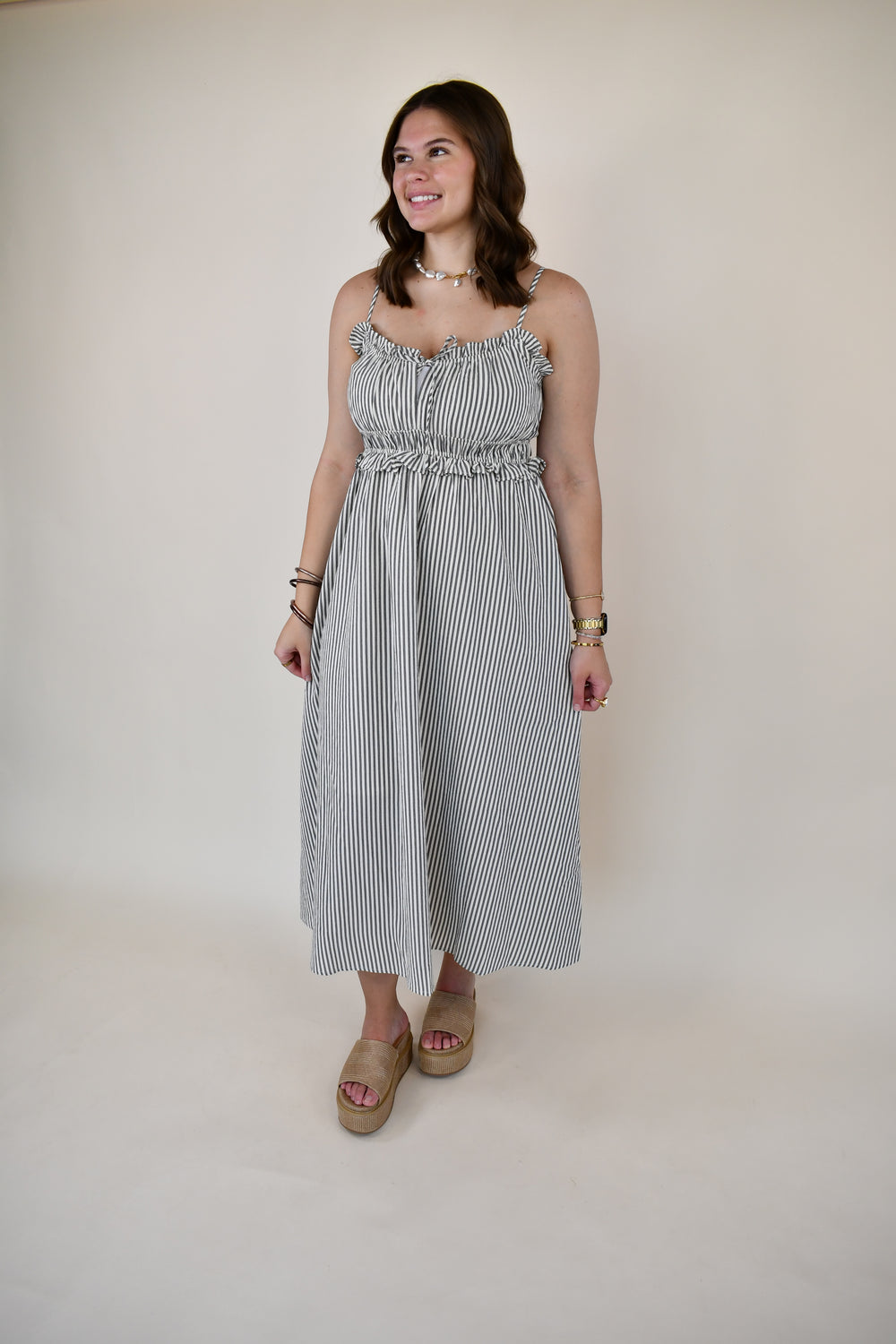 Women's striped sleeveless midi dress with adjustable spaghetti straps, a ruffle neckline, elastic waist, and lightweight flowy silhouette.