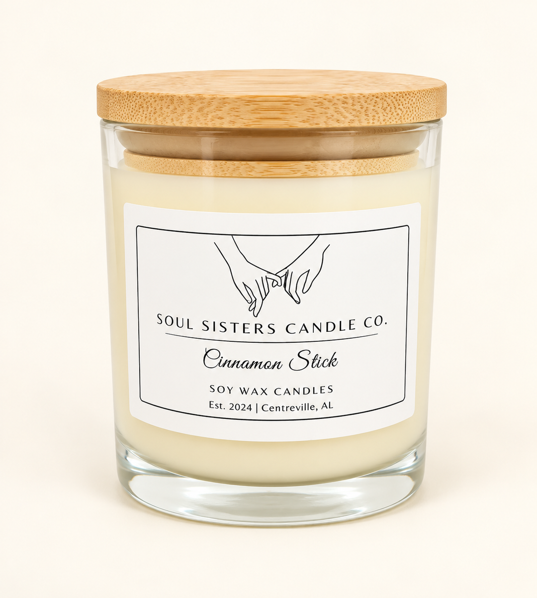 Soul Sisters Candle Co. Cinnamon Stick soy wax candle in a clear glass jar with natural wood lid and white label, featuring a warm cinnamon spice fragrance.