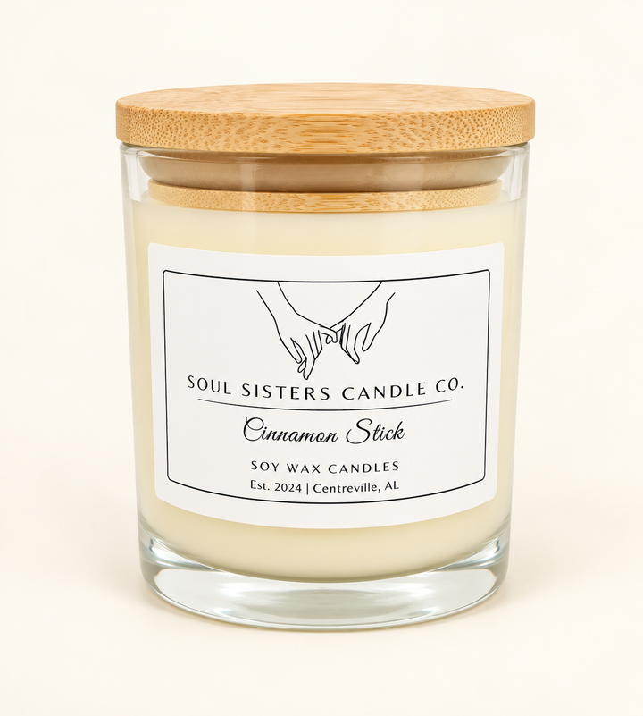 Soul Sisters Candle Co. Cinnamon Stick soy wax candle in a clear glass jar with natural wood lid and white label, featuring a warm cinnamon spice fragrance.