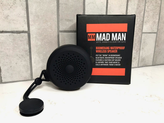 Black portable speaker with 'MAD MAN' branded packaging on a tiled wall background