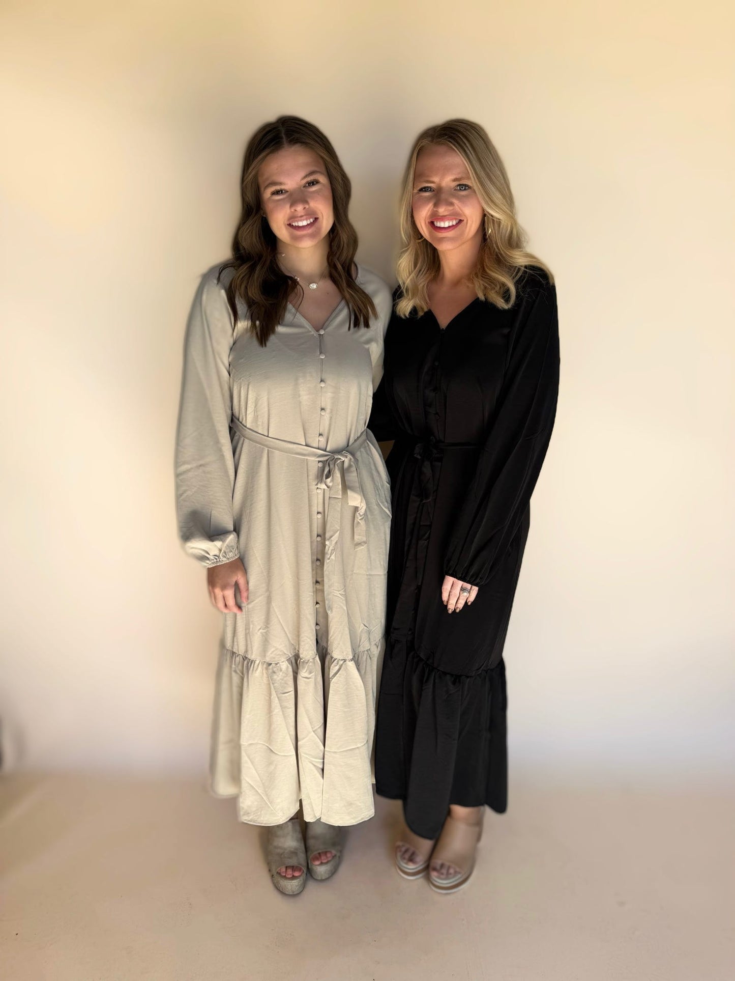 Two women standing side by side against a plain background