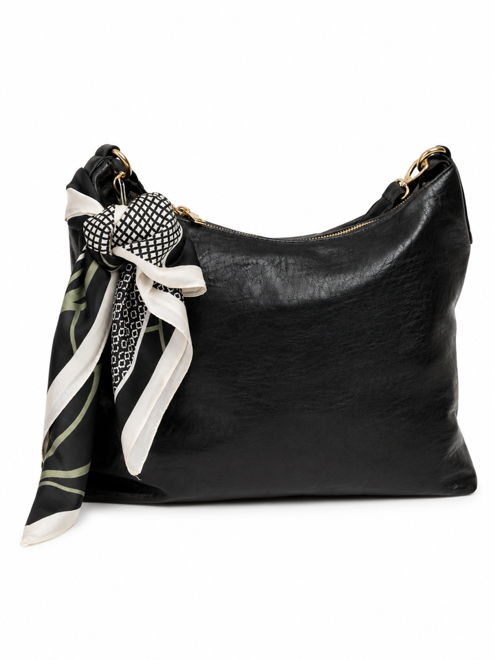 A black leather hobo shoulder bag with a gold-tone zipper, adorned with a black and white patterned silk scarf tied in a bow on the front.