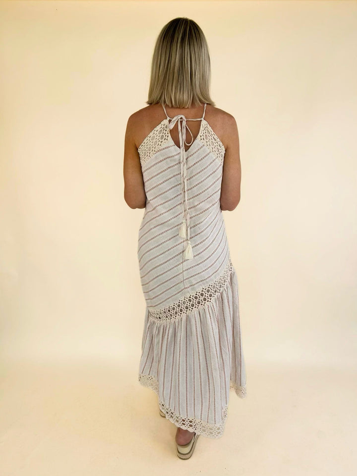 Back view of the Bella Halter Cutout Tiered Maxi Dress featuring a halter tie back, open back detail, and flowy maxi skirt.
