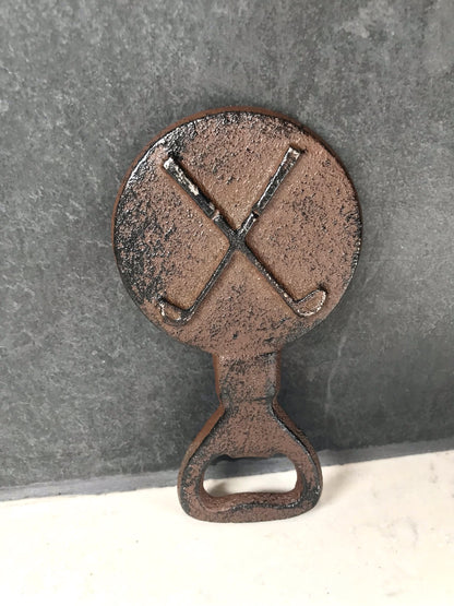 Black metal bottle opener with crossed golf clubs on a wooden background