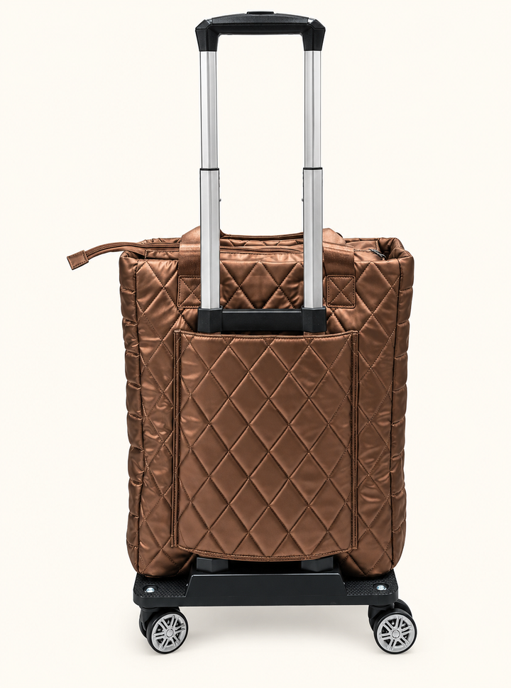 Back view of Simply Southern copper quilted rolling travel tote featuring an extended telescoping handle, diamond stitching, rear pocket, and swivel wheels.