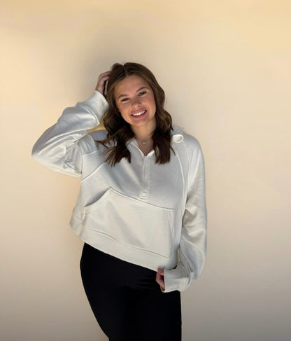 Person wearing a off white jacket against a plain background