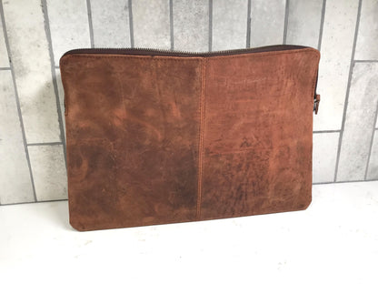 Brown leather pouch on a white surface with a tiled wall background