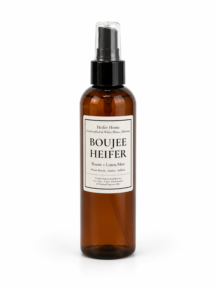 Heifer Home Boujee Heifer room and linen mist in an amber spray bottle featuring warm woods, amber, and saffron fragrance for refreshing rooms, linens, and fabrics.