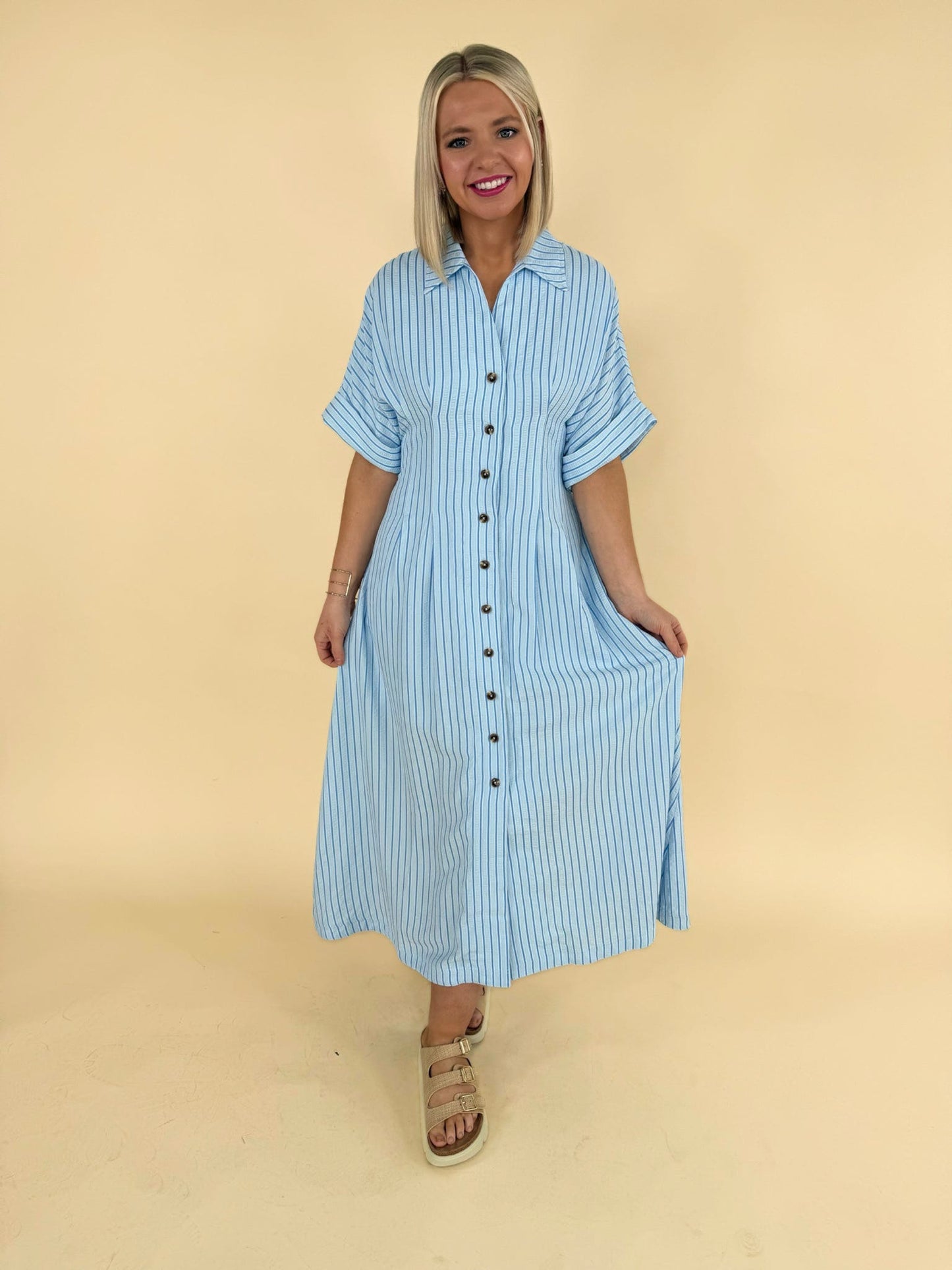 Light blue striped button down midi dress with short sleeves modeled for women’s boutique fashion