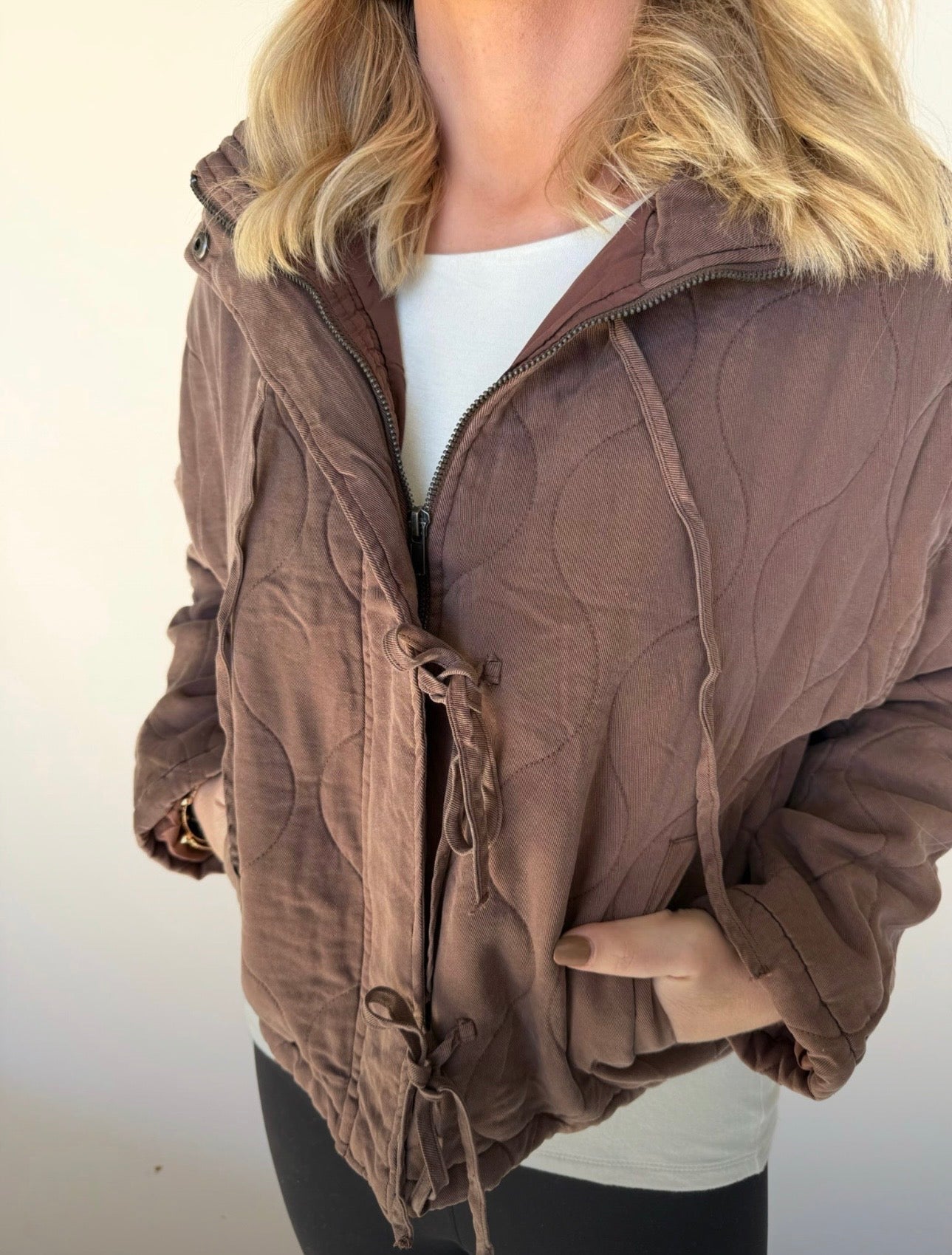 Brown jacket worn by a person on a plain background