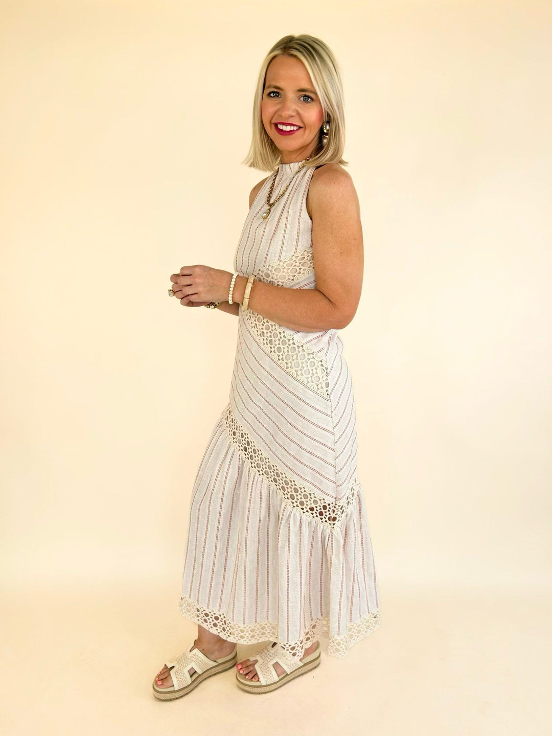 Side view of the Bella Halter Cutout Tiered Maxi Dress with a halter neckline, tiered silhouette, and crochet lace trim.