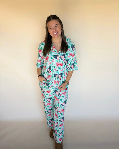 Woman wearing a holiday pajama set against a plain background