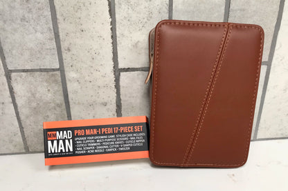 Brown leather wallet and orange box labeled 'MY MAD MAN' on a tiled floor.