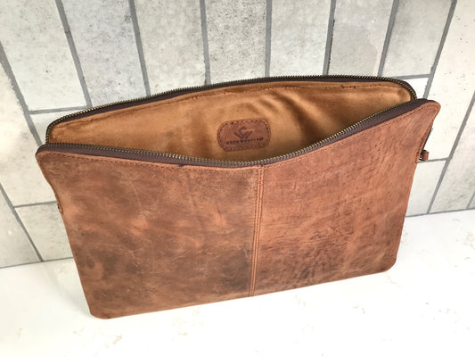 Brown leather pouch with a visible brand logo on a tiled floor background