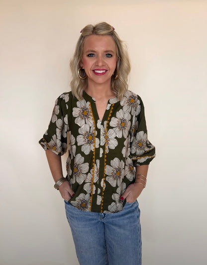 Woman wearing a floral blouse with a plain background