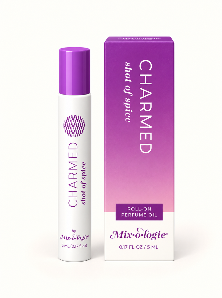 Mixologie Charmed Shot of Spice 5 mL roll-on perfume oil with purple cap and lavender-to-pink gradient packaging on a cream background.