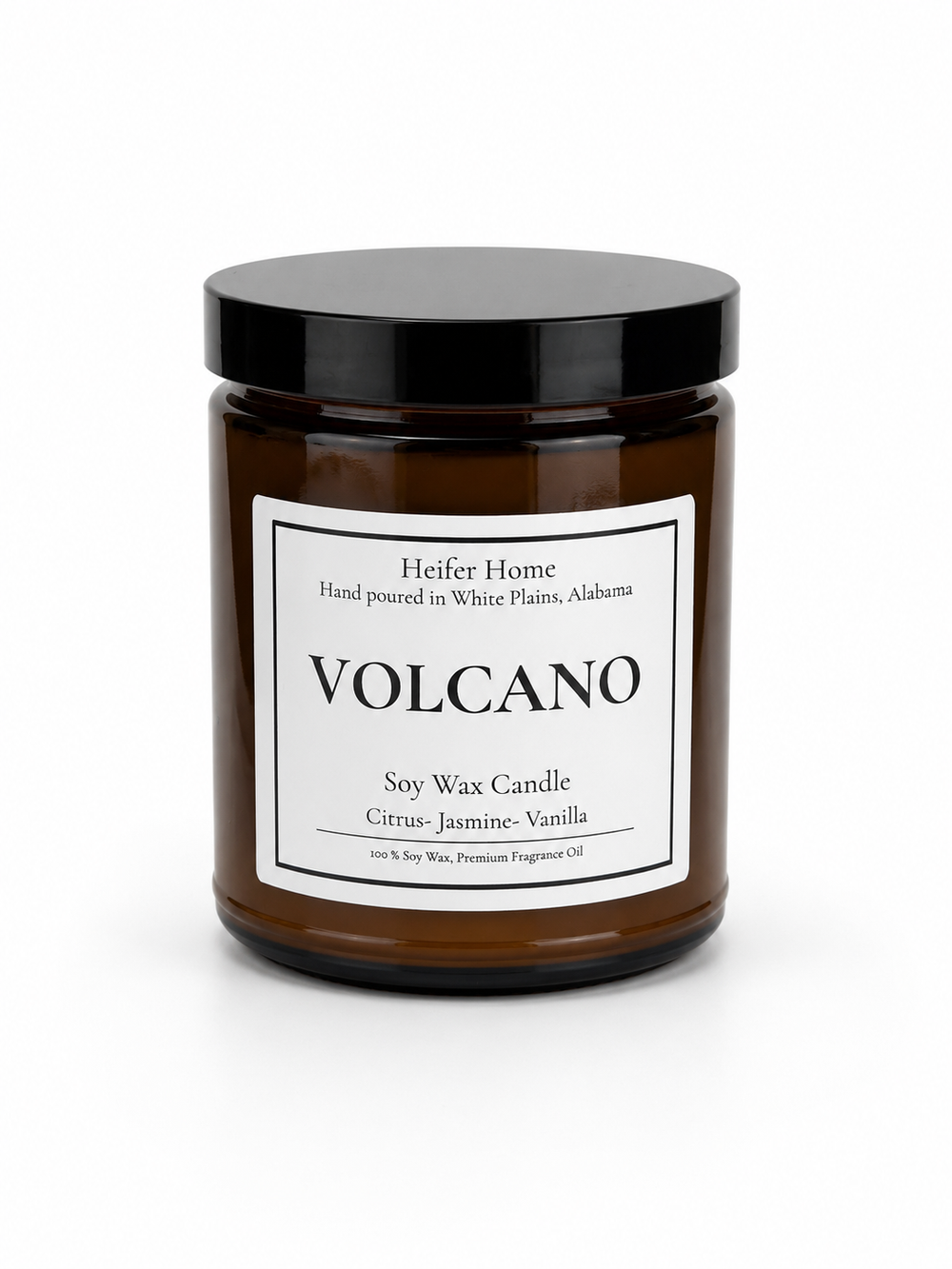 Heifer Home Volcano soy wax candle in an amber glass jar with a black lid featuring bright citrus, jasmine, and vanilla fragrance notes.