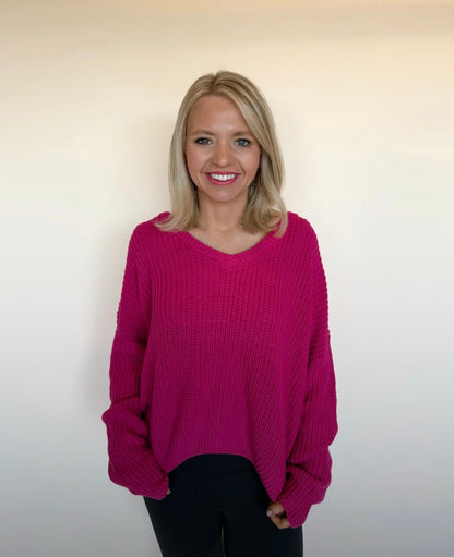 Woman wearing a pink sweater against a plain background