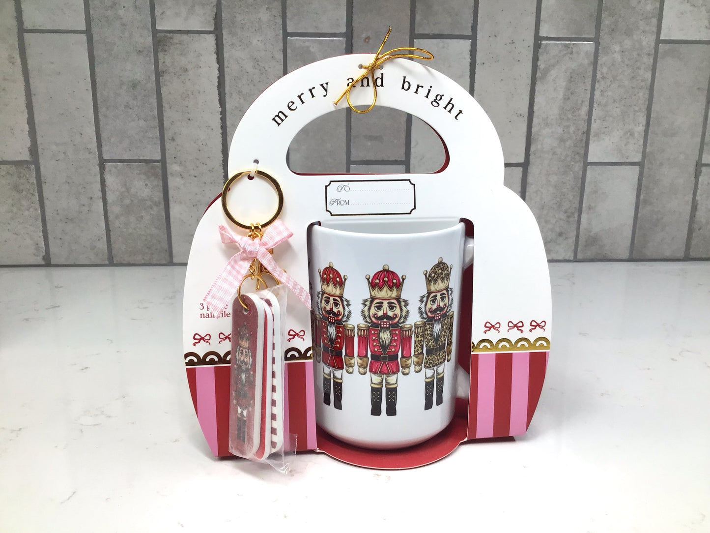“Nutcracker-themed ceramic mug gift set with red and gold nutcracker artwork and matching nail file keychain.