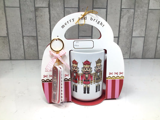 “Nutcracker-themed ceramic mug gift set with red and gold nutcracker artwork and matching nail file keychain.