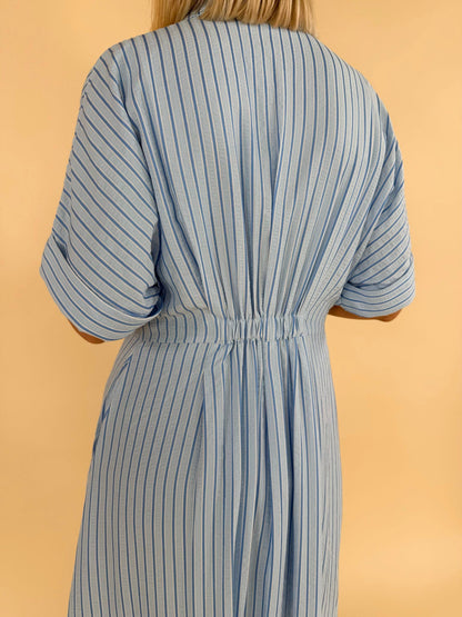 Close up back detail of light blue striped midi dress with elastic waist women’s boutique clothing