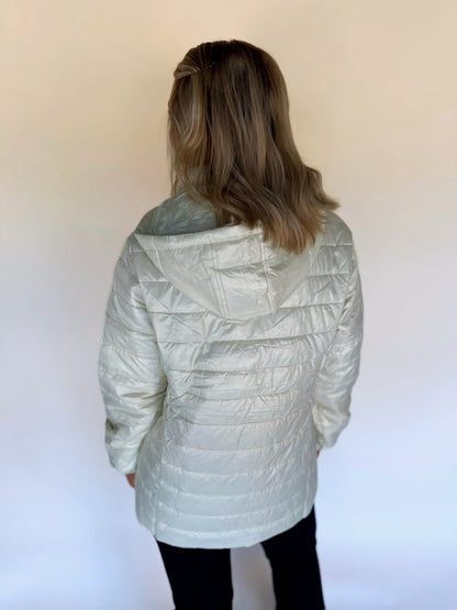 Person wearing an ivory quilted jacket on a white background