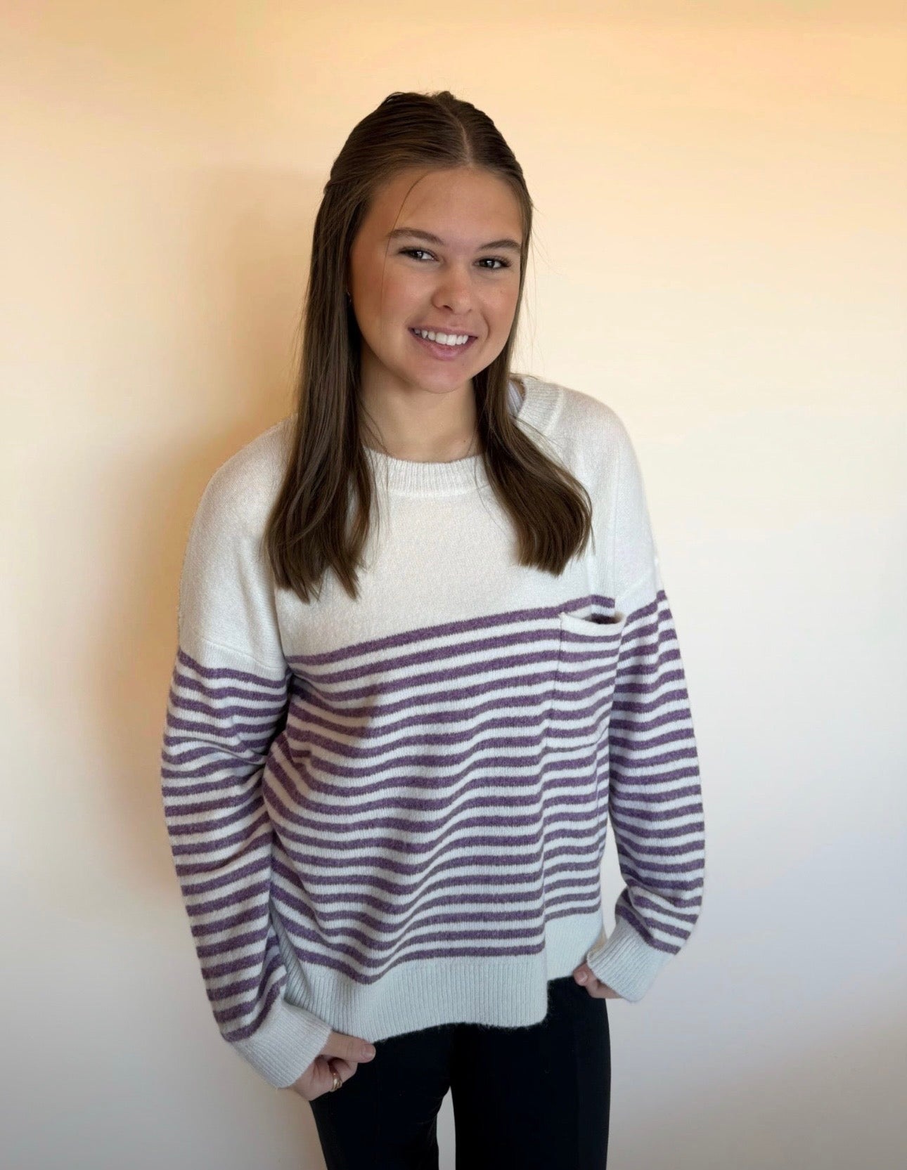 Person wearing a striped sweater against a plain background
